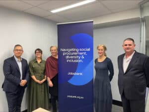Five people, all dressed in professional clothes, stand in front of a Jobsbank banner. There are three women and two men.