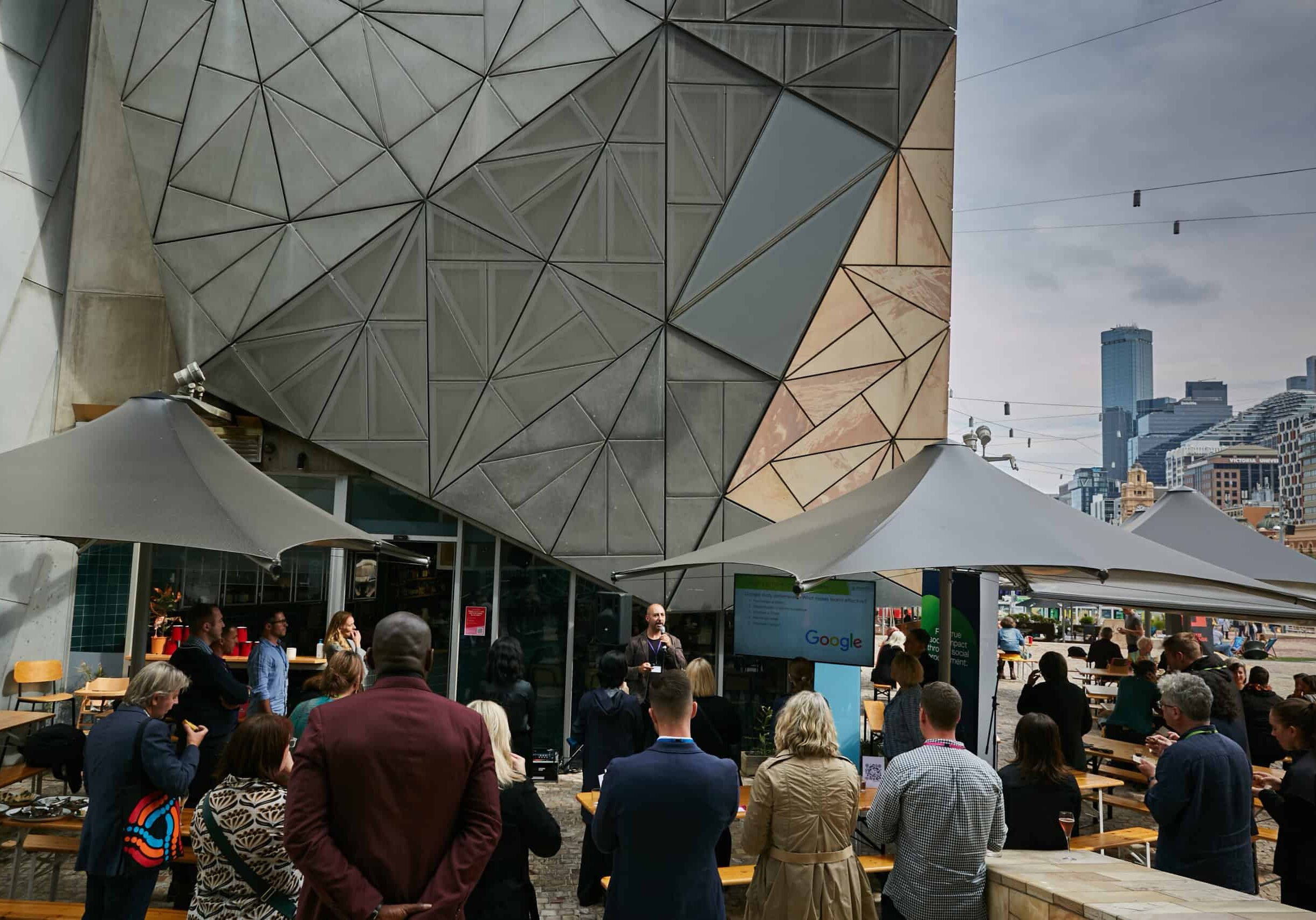 An crowd of people gathered in Melbourne's Federation Square, listening to a speaker at Jobsbank's first Meet The Suppliers event.